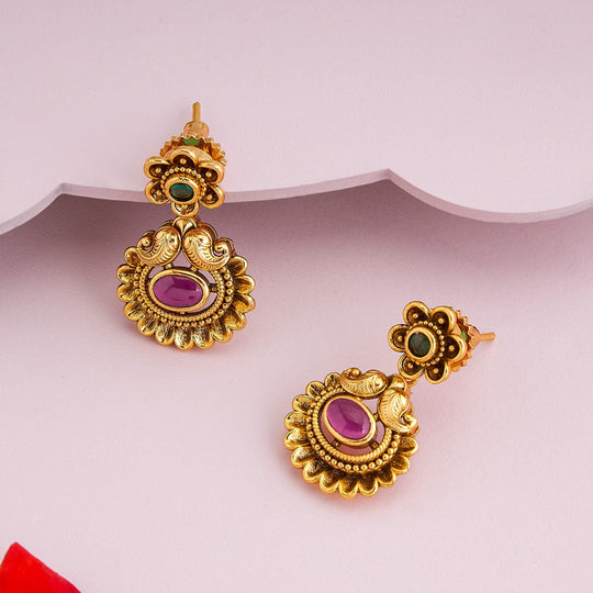 Antique temple earrings with green and pink stones, floral motif, angled view.