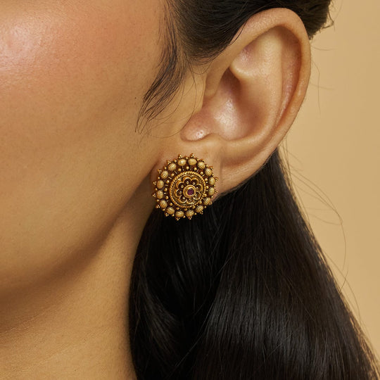 Antique temple stud earring with ruby stones worn by a model.