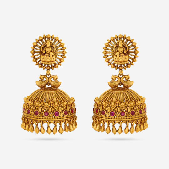 Antique gold polish jhumka earrings with peacock motif and ruby-red stones.