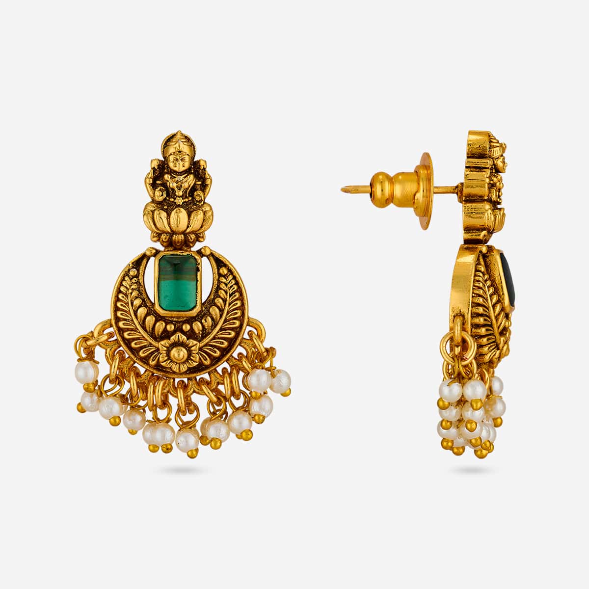 Pair of antique earrings with green stones and pearl drops on white background.
