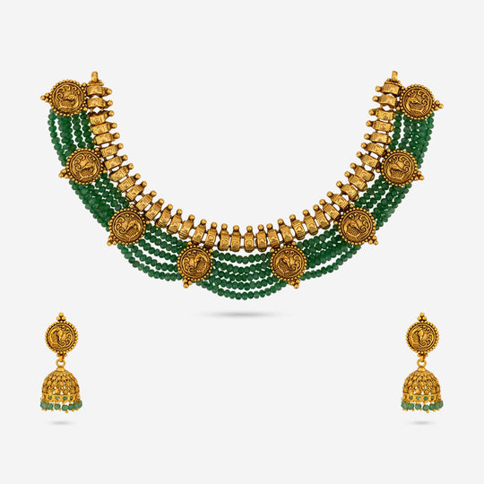 Antique temple necklace and earrings set with green beads and peacock motifs.