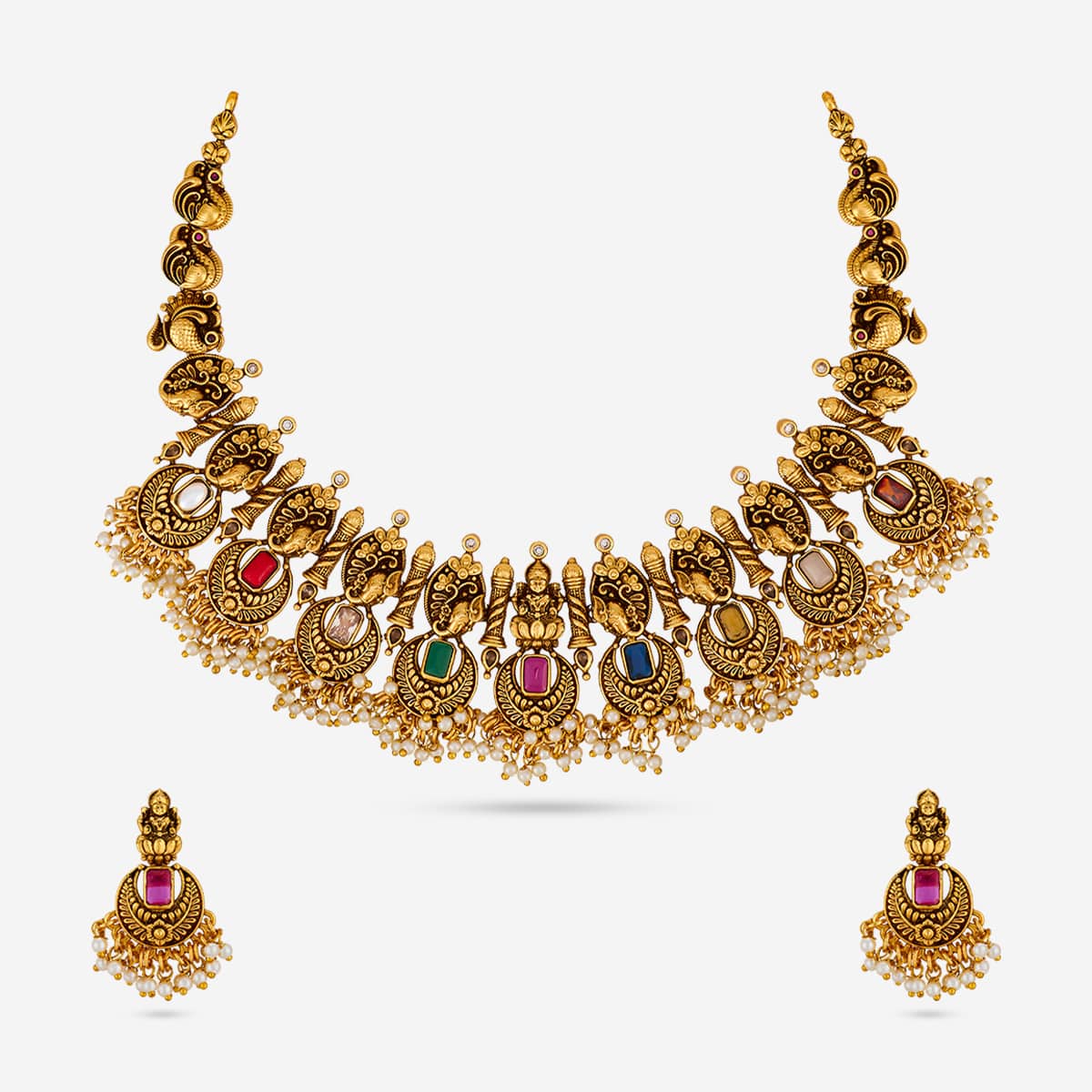 Antique necklace set with multicolored stones and pearl drops on white background.