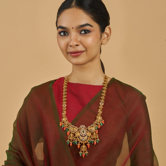 Antique temple necklace with peacock motif worn by model, ruby and green stones.