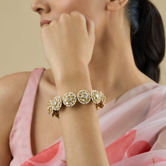 Model wearing antique floral Kundan bangle with white stones.