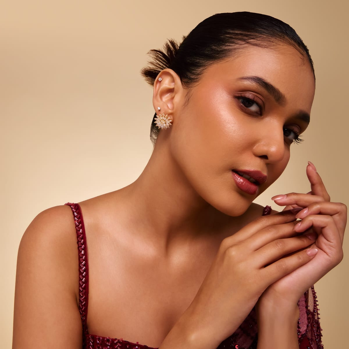 Model wearing cluster zircon stud earrings with clear stones.