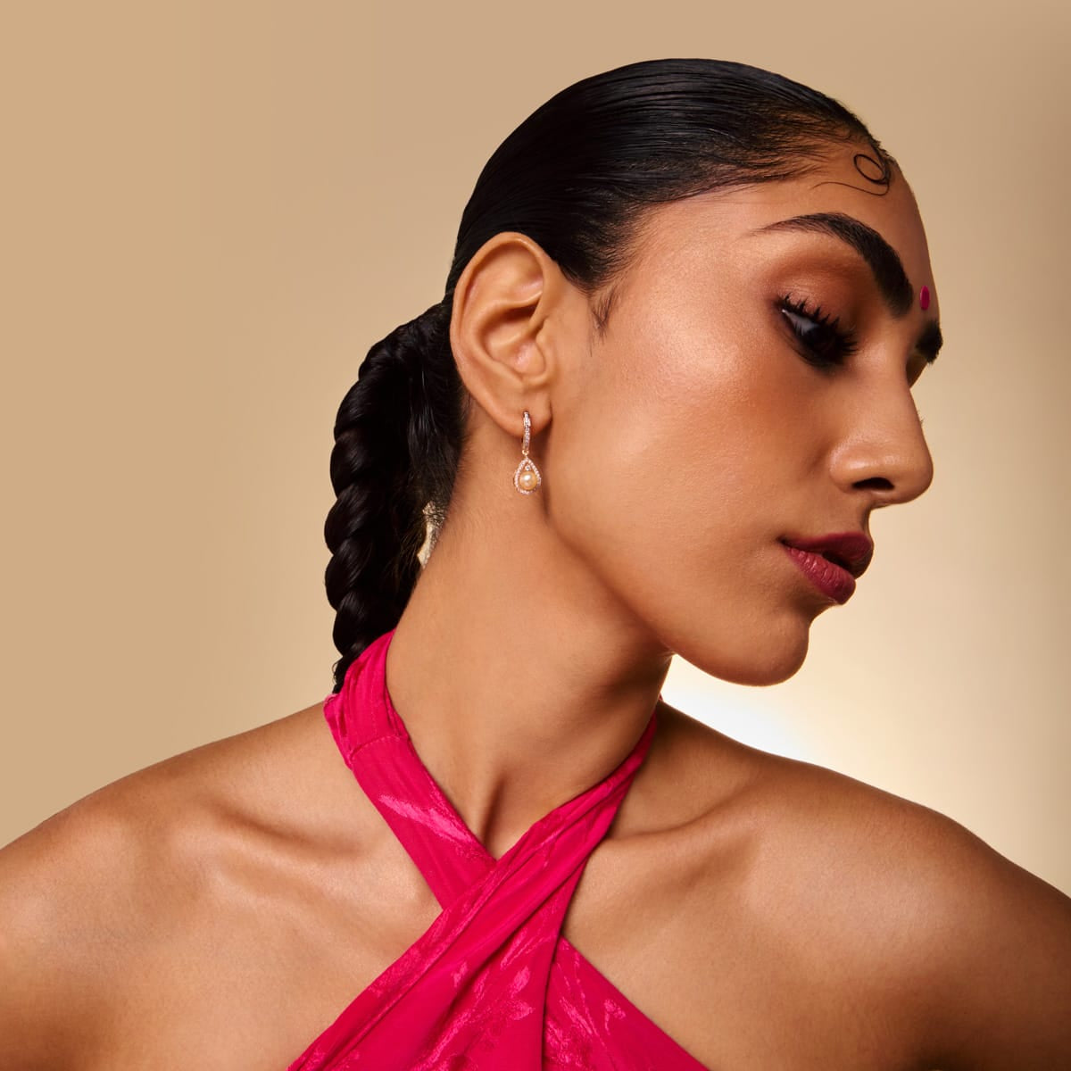 Model wearing gold-tone zircon teardrop hoop earring with white stones.