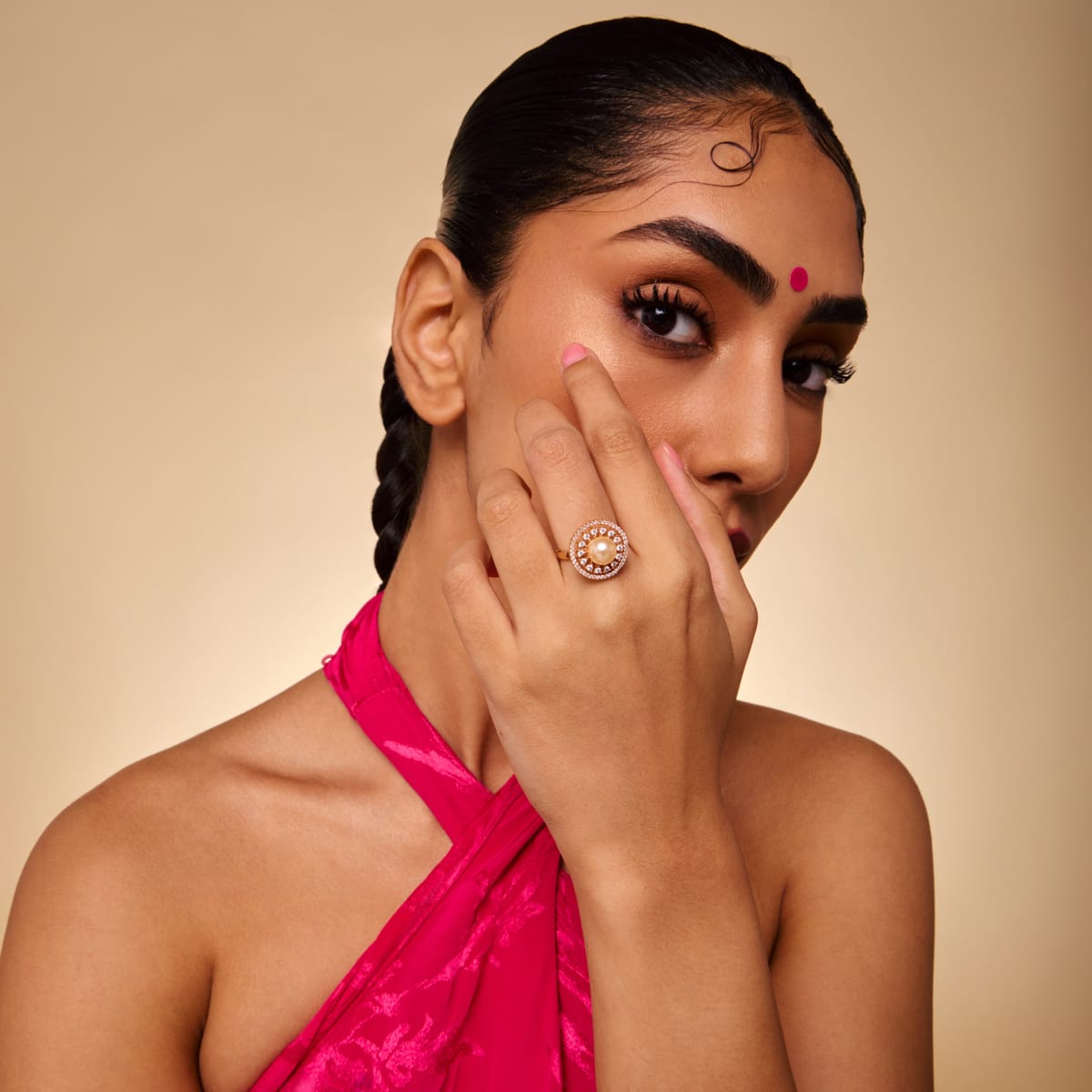 Model wearing gold-tone zircon ring with cream pearl center.