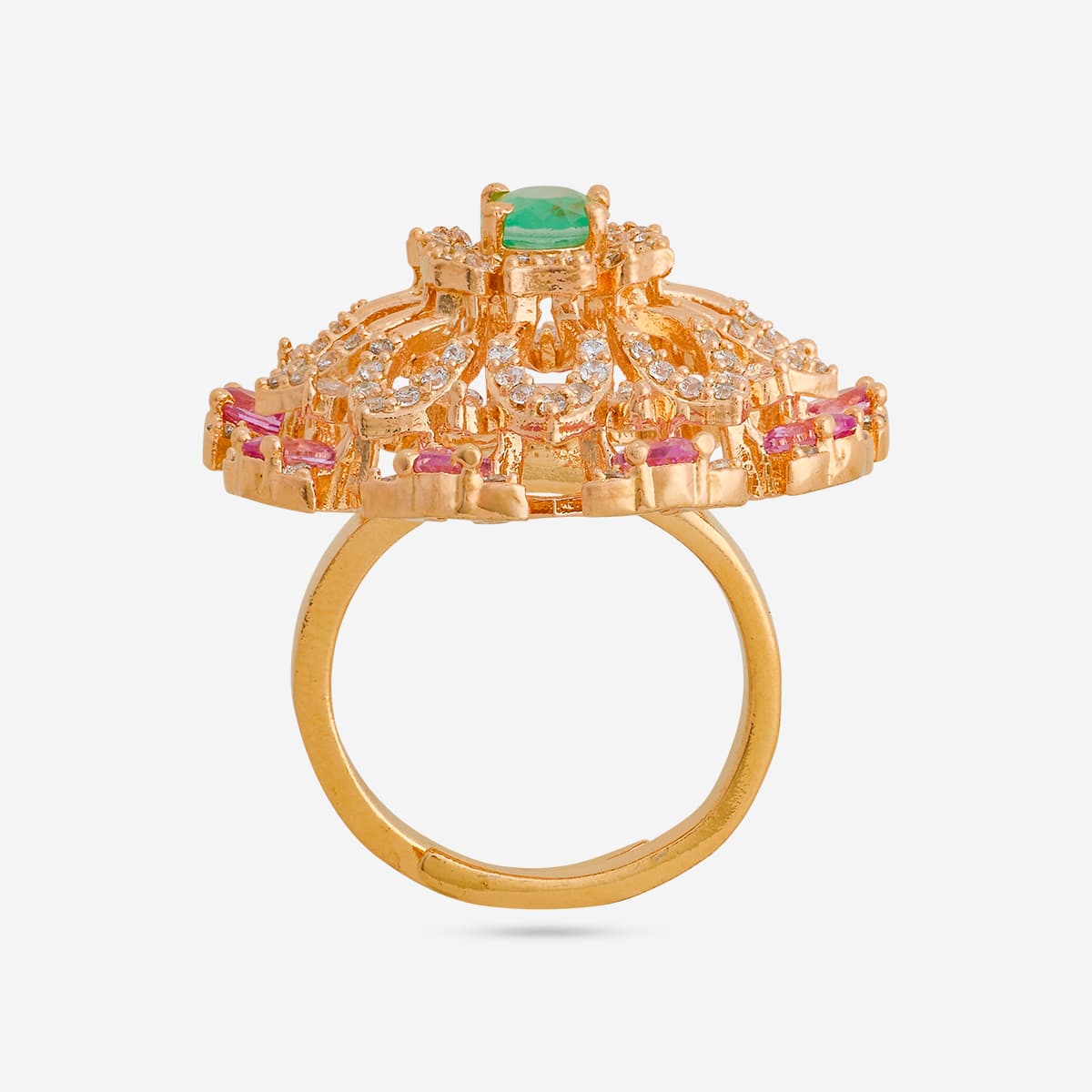 Gold-tone finger ring with green center stone and pink accents, side view.