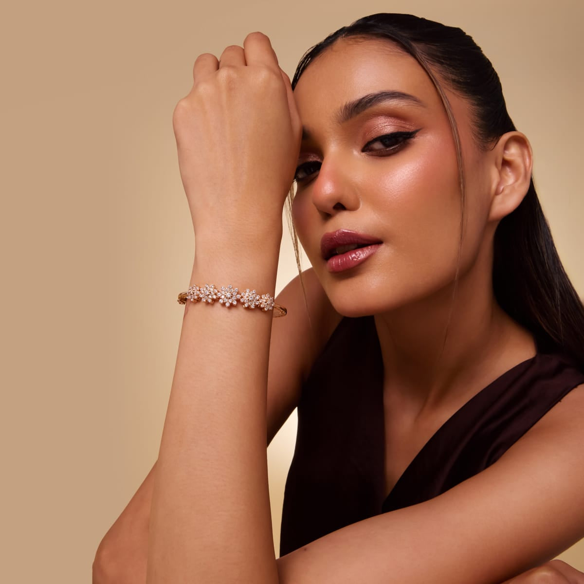 Gold-tone zircon cluster kada worn by model, close-up.