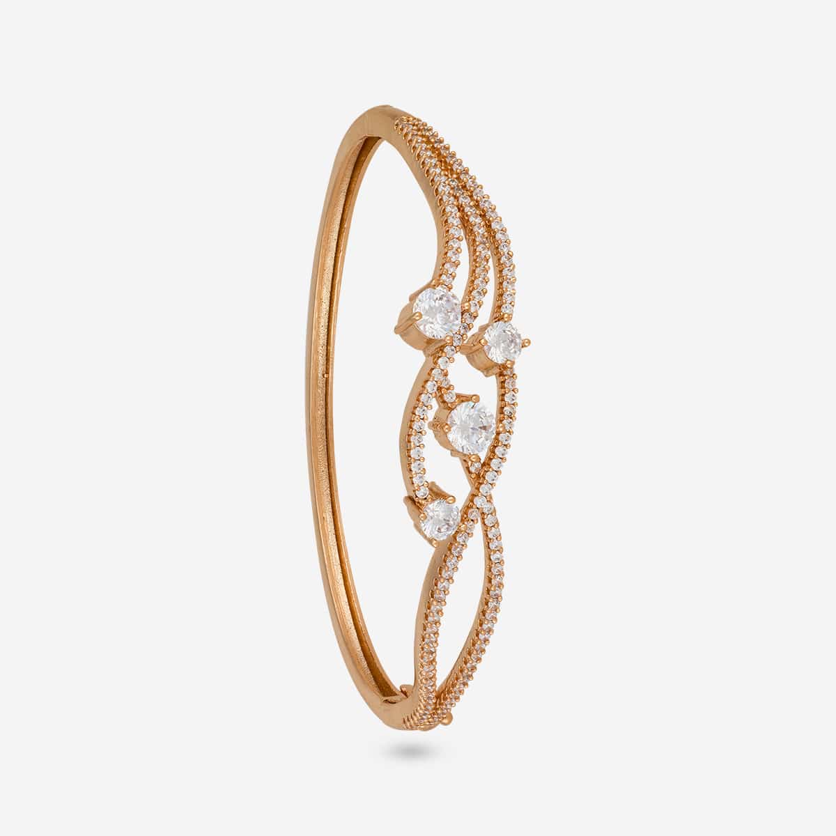 Gold-tone zircon kada with intricate design and white stones, side view.