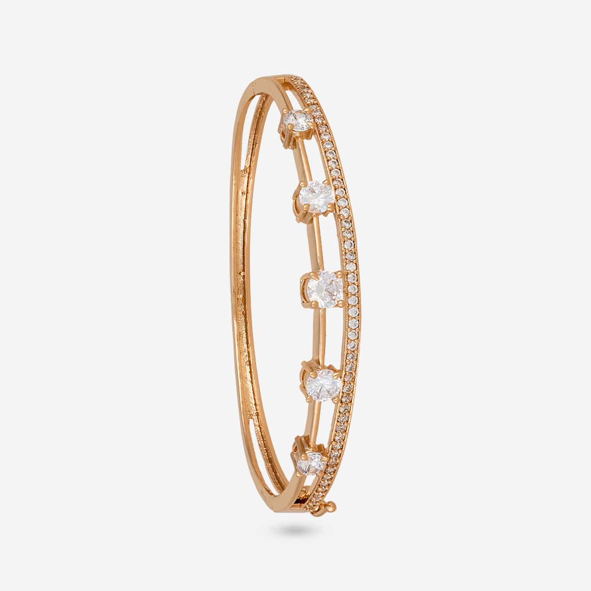 Gold-tone zircon kada with white stones, side view on white background.