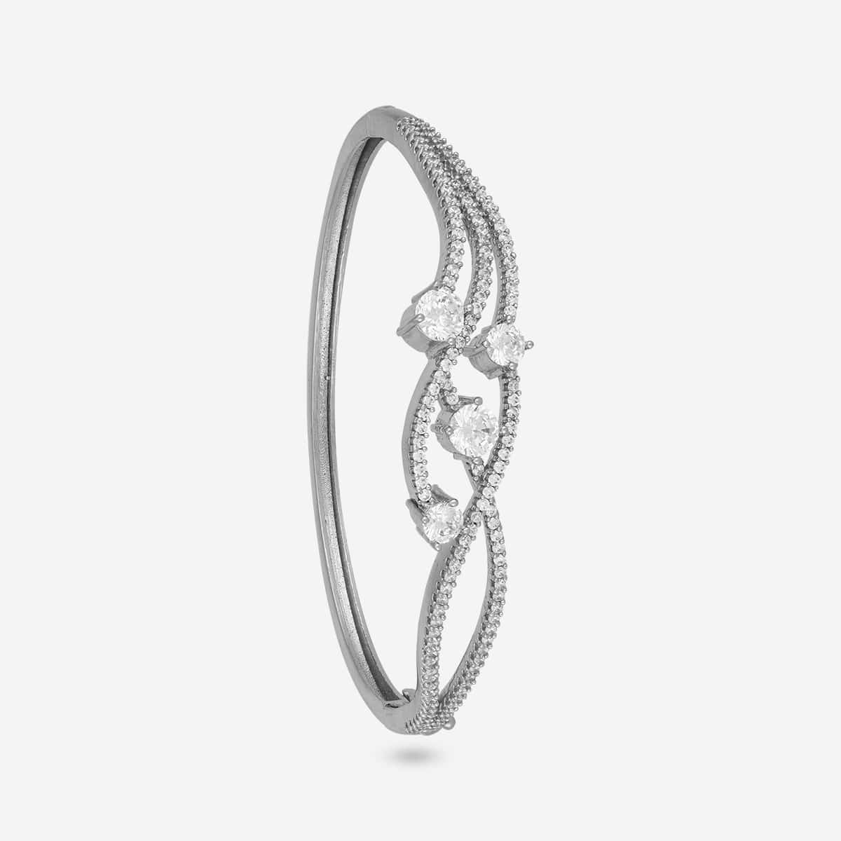 Silver-tone zircon kada with intricate design and white stones, side view.