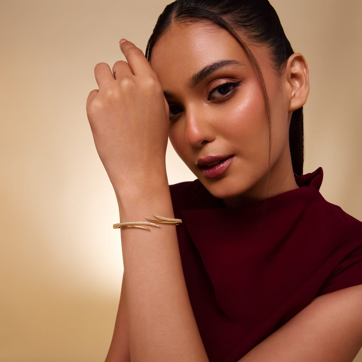 Gold-tone zircon kada worn by model, showcasing elegant design.