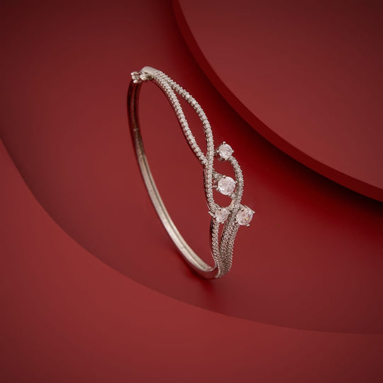 Silver-tone zircon kada with white stones, displayed on a red background.