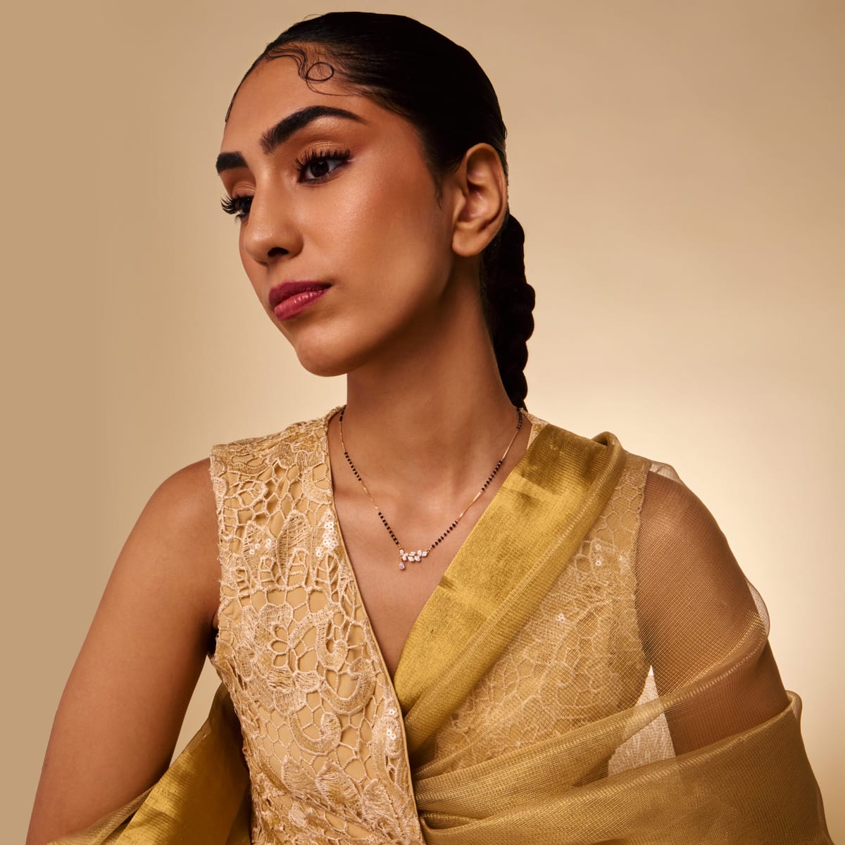 Model wearing zircon mangalsutra with teardrop pendant over traditional attire.
