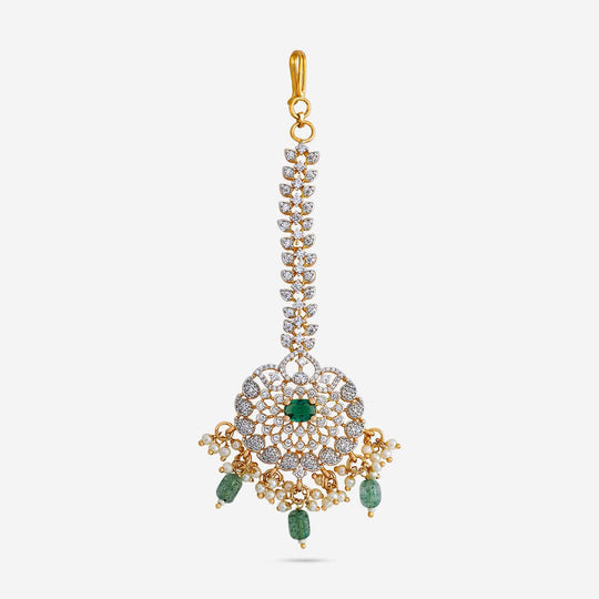 Floral zircon tikka with green and white stones, gold polish, on white background.